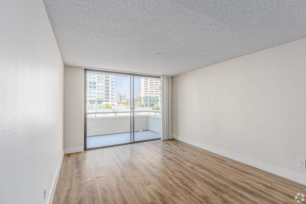 Kitchen with dining table connecting to a living room of an apartment at Market Street Square in San Diego, California