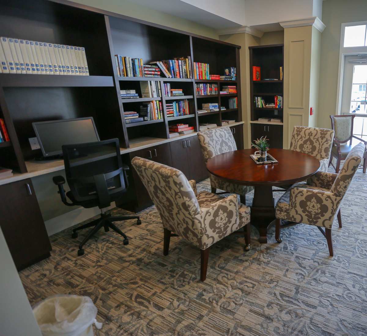 Community room with bookshelf at Harmony at Spring Hill in Lorton, Virginia