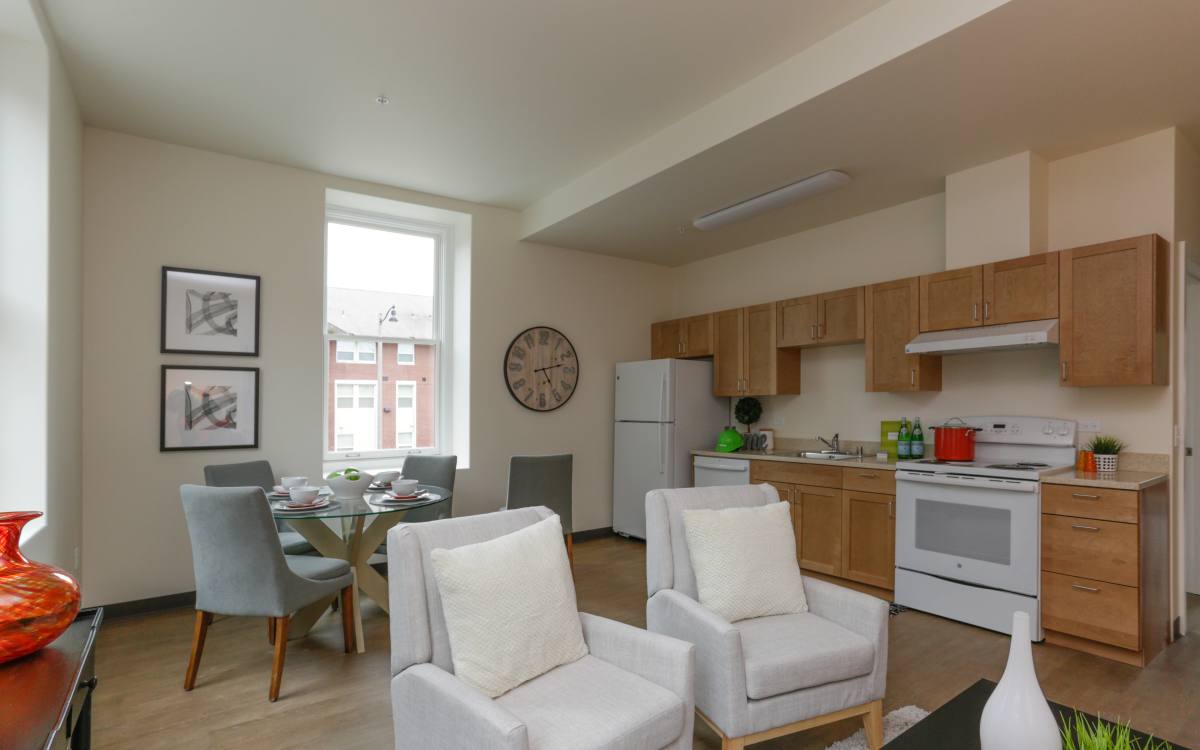 Open kitchen with dining table and sofas at Mercy Magnuson Place South in Seattle, Washington