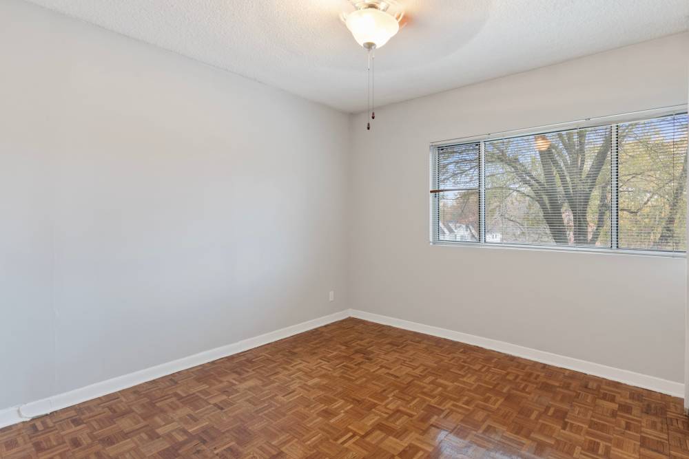 Spacious bedroom with wood floor and natural light at Central Gardens in Memphis, Tennessee