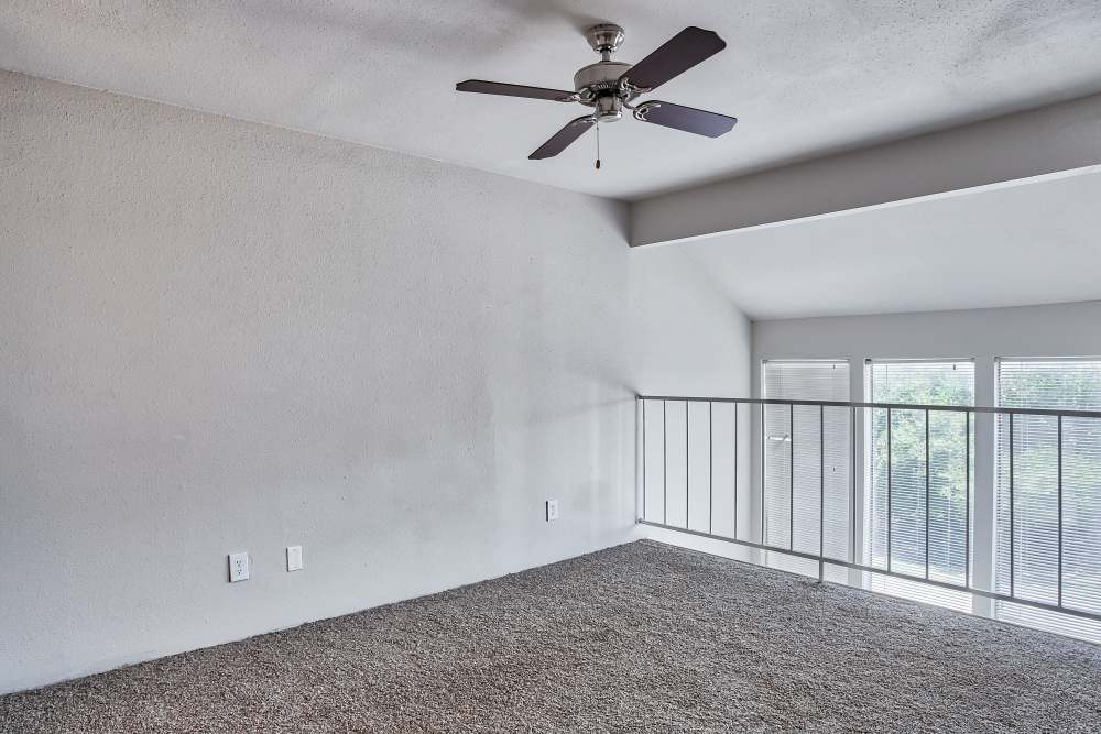 Carpet floored apartment in the upstairs at Branch Creek Apartments in Carrollton, Texas
