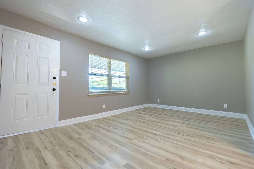Unfurnished living room with wood-style flooring at Lakeshore Villa Apartments in Rowlett, Texas