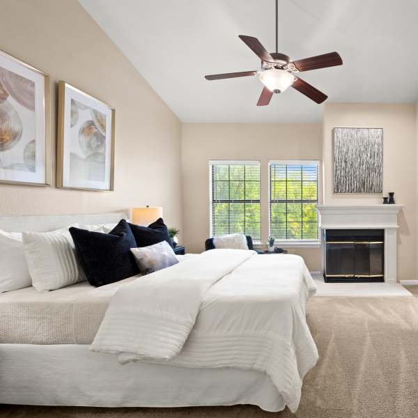 A bedroom with a ceiling fan at Villas at Parkside in Farmers Branch, Texas