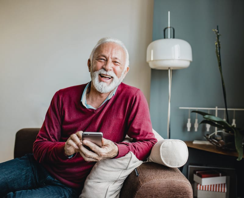 Smiling resident sitting on a comfy chair in their home at Ebenezer Ridges Campus in Burnsville, Minnesota 