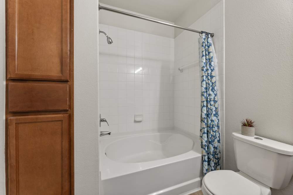 Bathroom with a tub and its curtain at Costa Ibiza in Houston, Texas