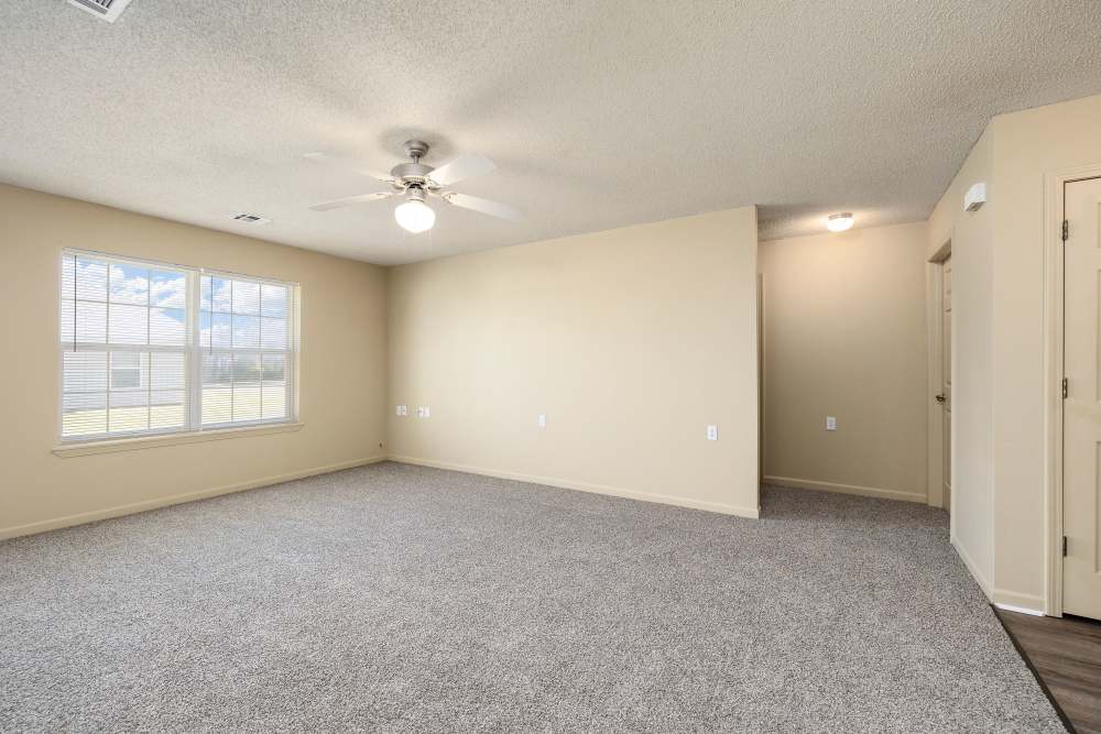 Spacious living area with abundant natural light and plush carpeting at Prairie Hill Estates II in Carl Junction, Missouri.