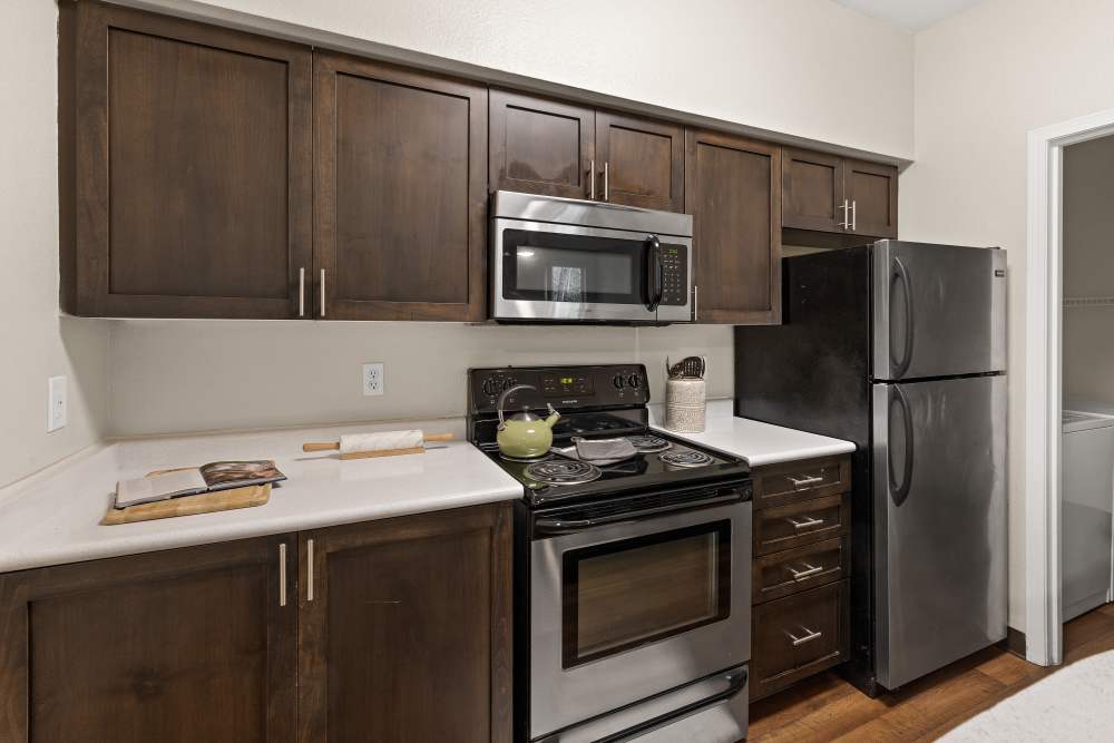 Kitchen with brown cabinetry at Wildreed Apartments in Everett, Washington