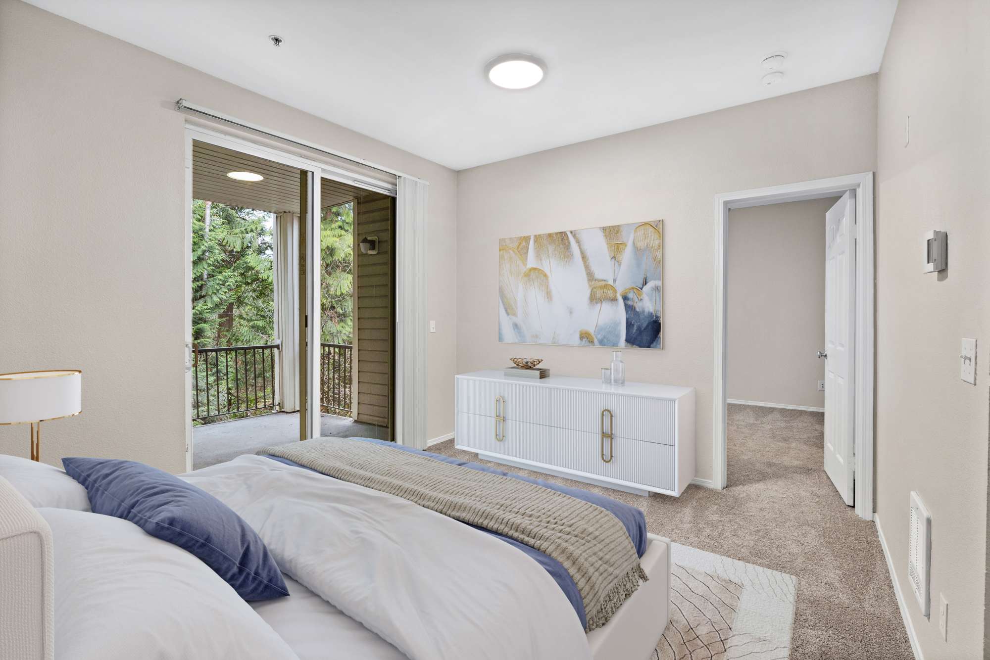 Bedroom with patio access at Wildreed Apartments in Everett, Washington