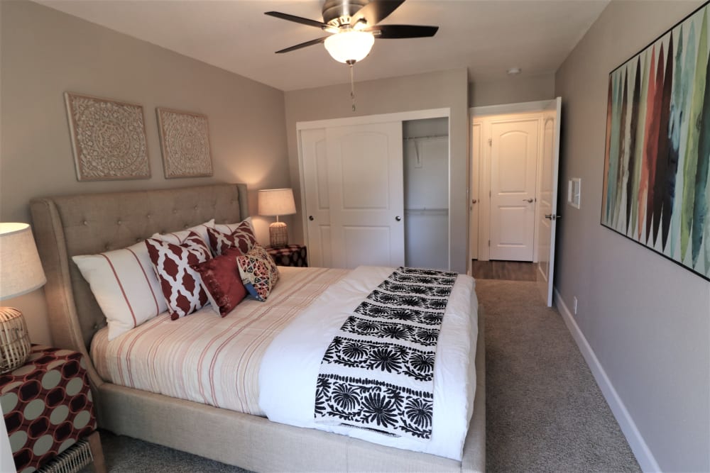 Model bedroom with ceiling fan at Pinebrook Apartment Homes in Fremont, California