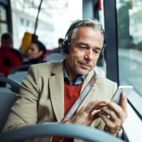 Resident on the bus using his phone near Town Center Apartments in Lafayette, California