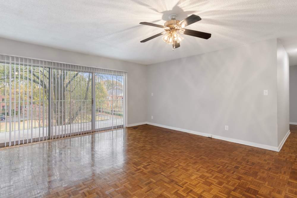 Spacious living area with stylish wood flooring and access to the patio at Central Gardens in Memphis, Tennessee