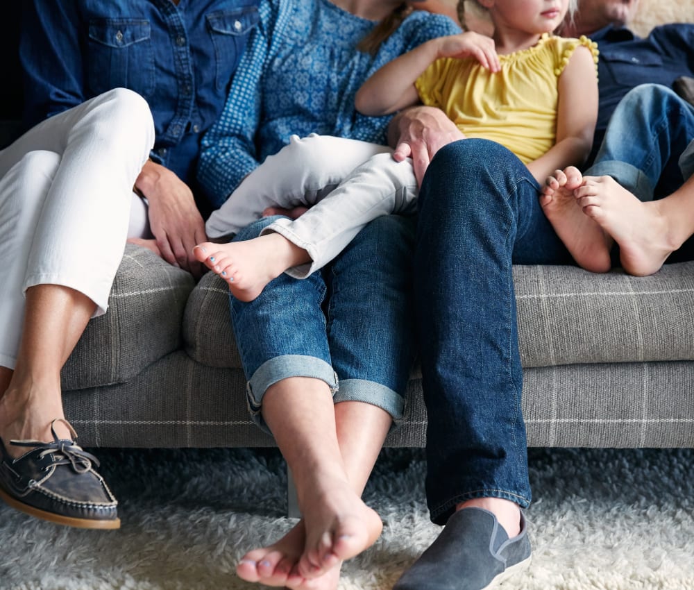 Family relaxing together on the couch in their home at Sofi at Cedar Mill in Portland, Oregon