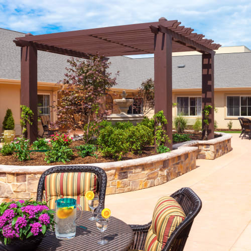 Patio seating by the garden at Saddlebrook Oxford Memory Care in Frisco, Texas