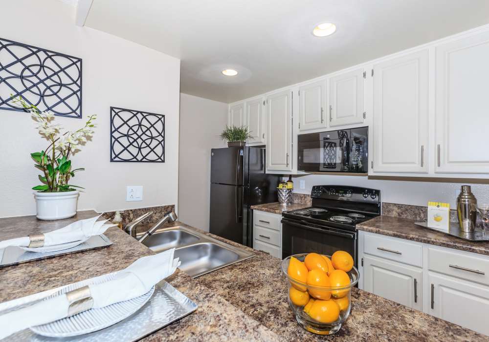 Kitchen with refrigerator at Parcwood Apartments in Corona, California, 