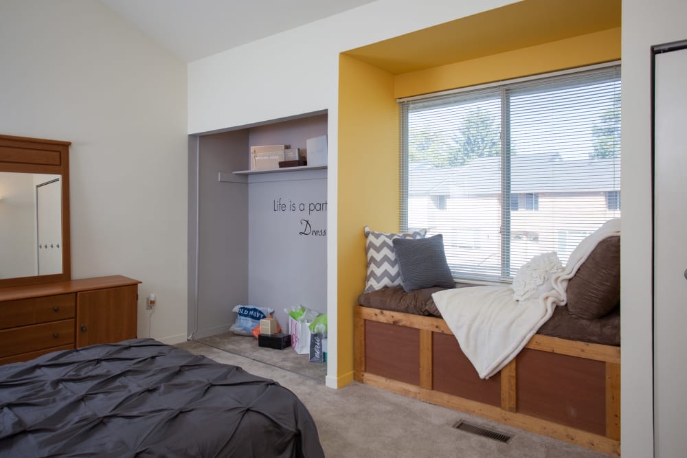 Model bedroom with a window bench seat at Brockport Crossings Apartments & Townhomes in Brockport, New York