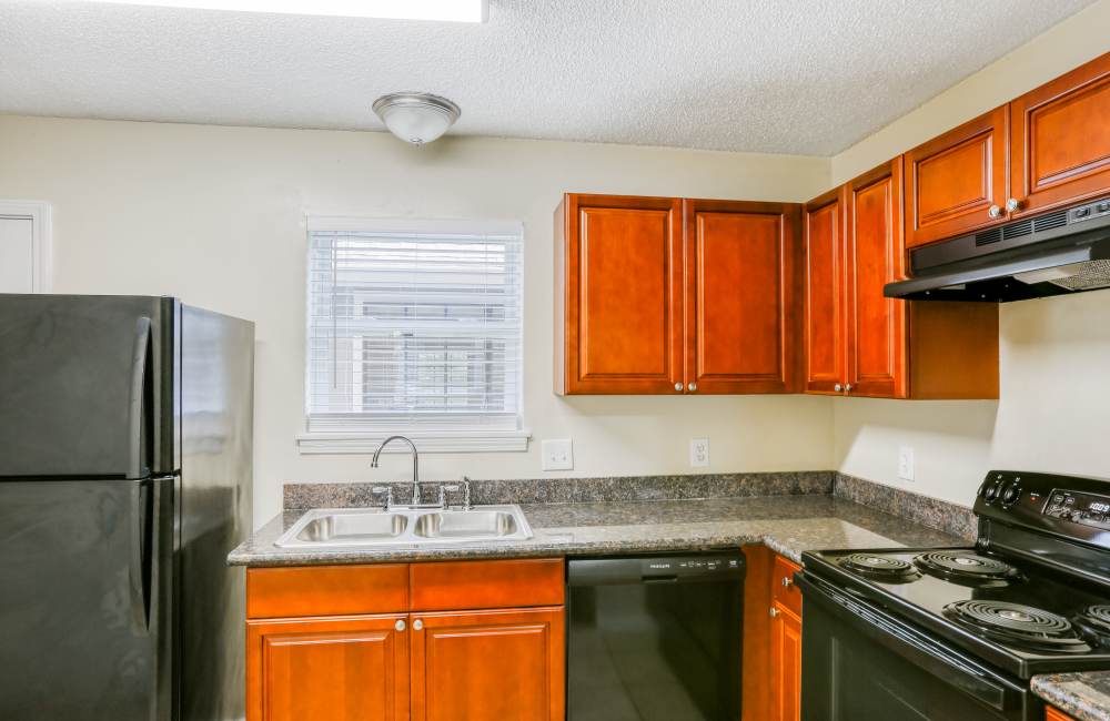 Granite countertops and wooden cabinets in the kitchen at Creekwood Townhomes in Hammond, Louisiana