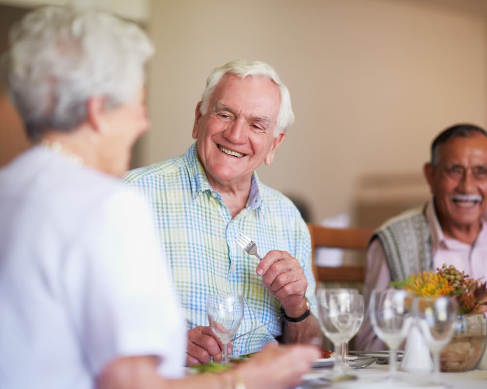 Senior living residents enjoying a meal in the dining area at The Gardens at Creekside