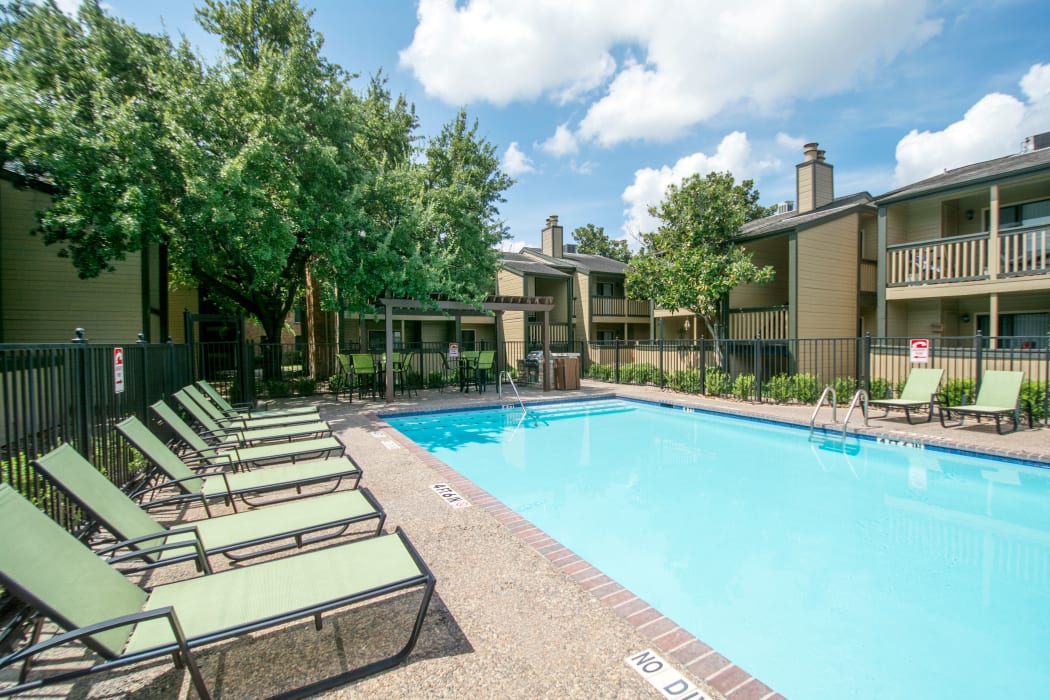 Swimming pool with lounge chairs at Stonecrossing of Westchase in Houston, Texas