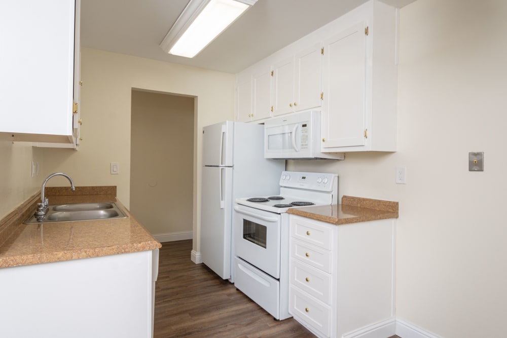 Updated kitchen with white finishes at Bayfair Apartment Homes in San Lorenzo, California