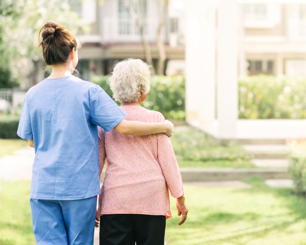 Resident and staff walking together at Arlington Place of Pocahontas in Pocahontas, Iowa.