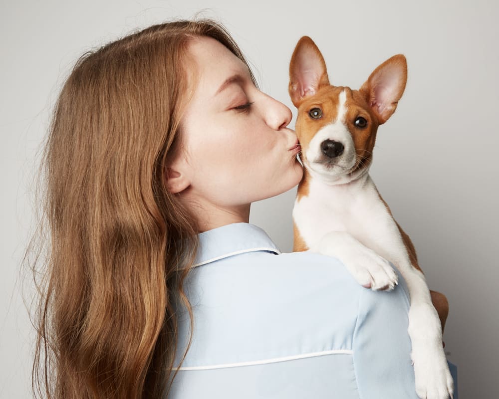 Resident giving her puppy some love in their new home at Capitol Flats in Santa Fe, New Mexico