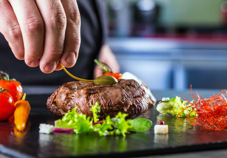 Chef topping off a steak at The Montera in La Mesa, California