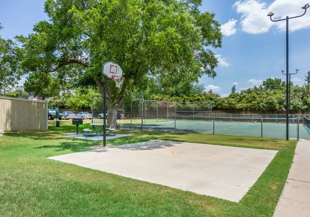 Recreation area with basketball court and lush greenery at Charter Oak in Euless, Texas.