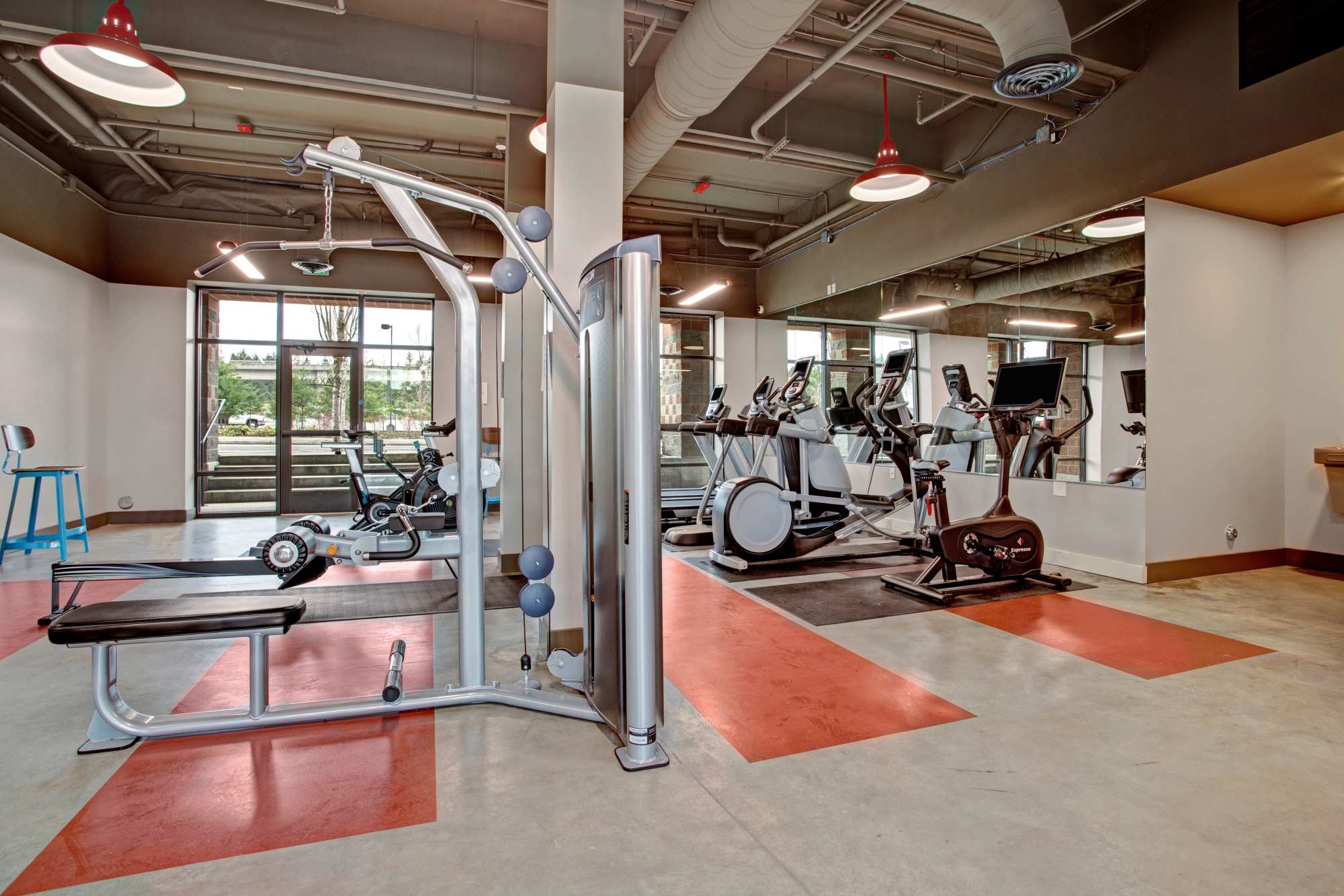 Fitness center with treadmills and bench press at Trax at Dupont Station in Dupont, Washington