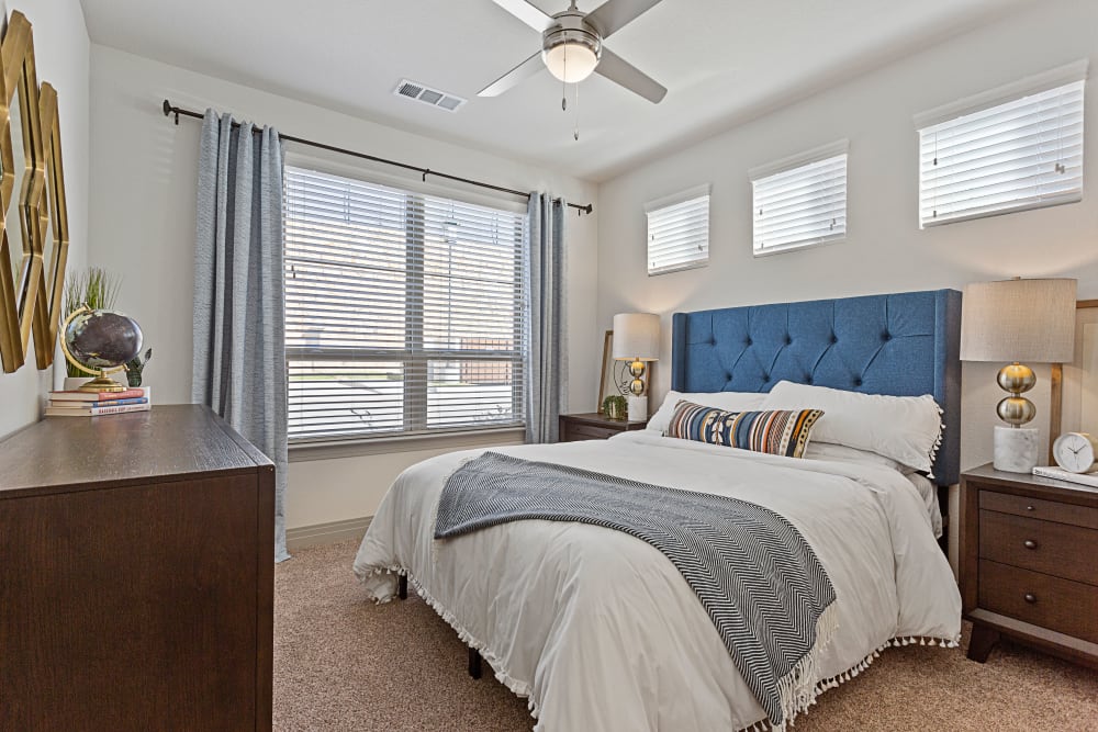 Primary bedroom with large windows and ceiling fan at Olympus Hudson Oaks in Hudson Oaks, Texas