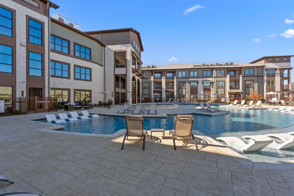 Resort style pool and lounge chairs at Olympus Hudson Oaks in Hudson Oaks, Texas