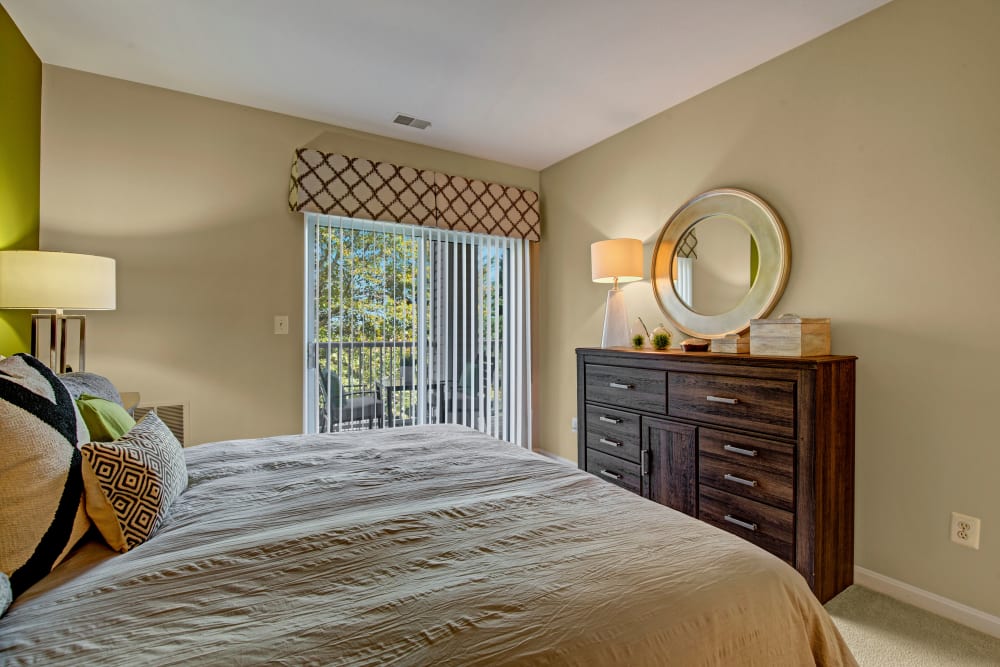 Model bedroom with door to private balcony at Windsor Commons Apartments in Baltimore, Maryland