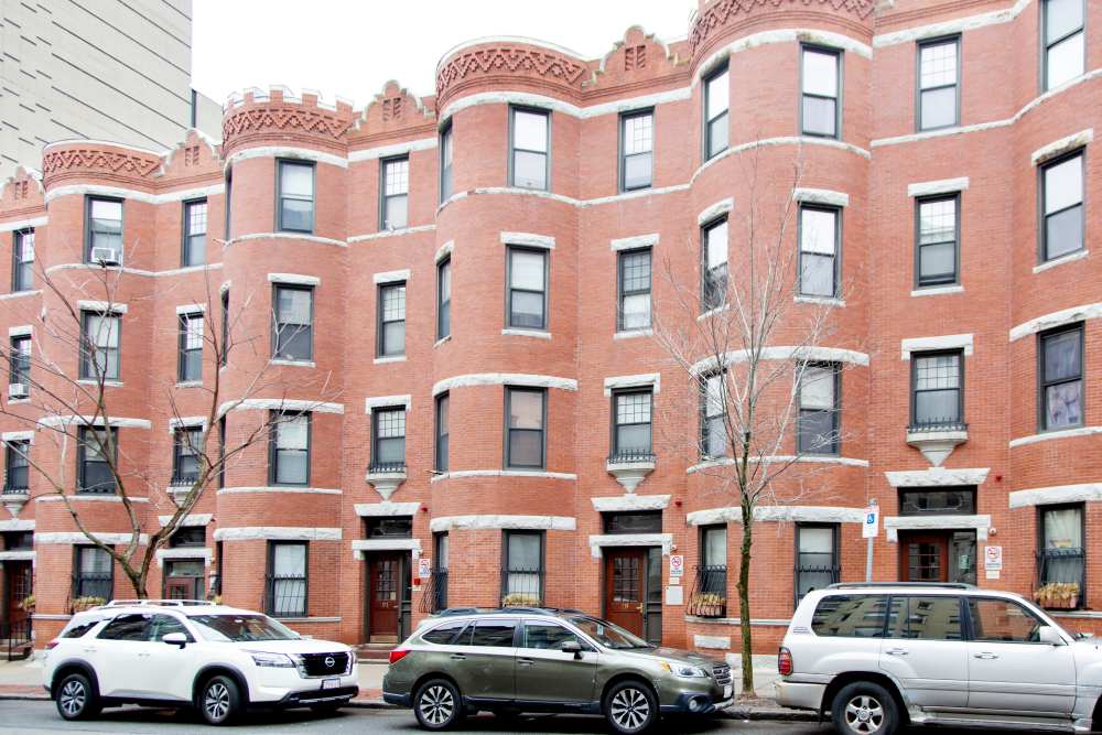 Historic brick apartment building with multiple windows and trees in front at 15-25 Hemenway Apartments in Boston, Massachusetts