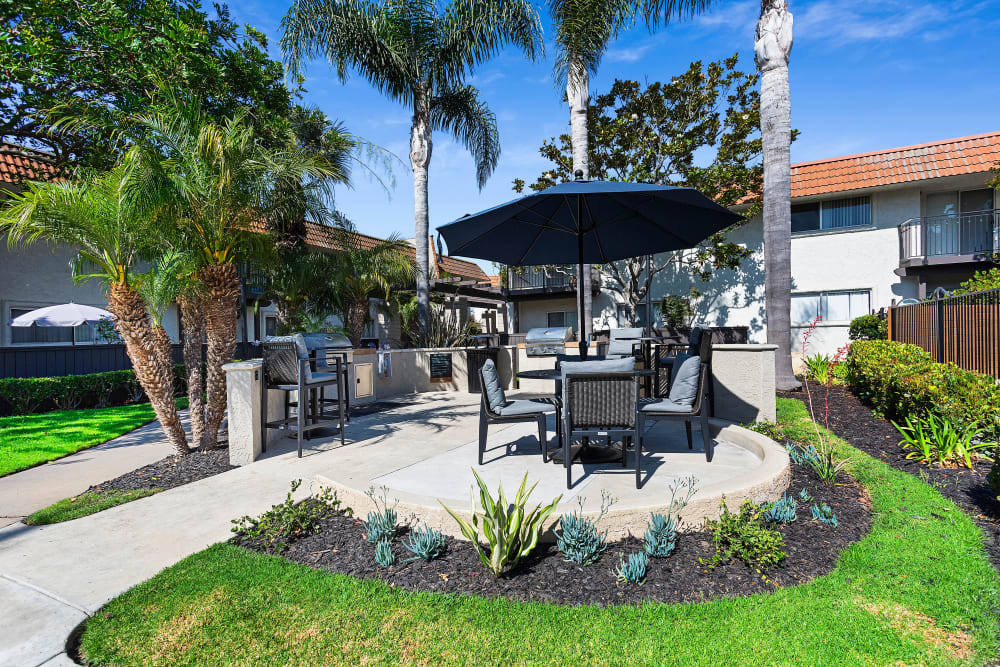 Property barbecue area with seating and shade umbrellas at Terra Camarillo in Camarillo, California