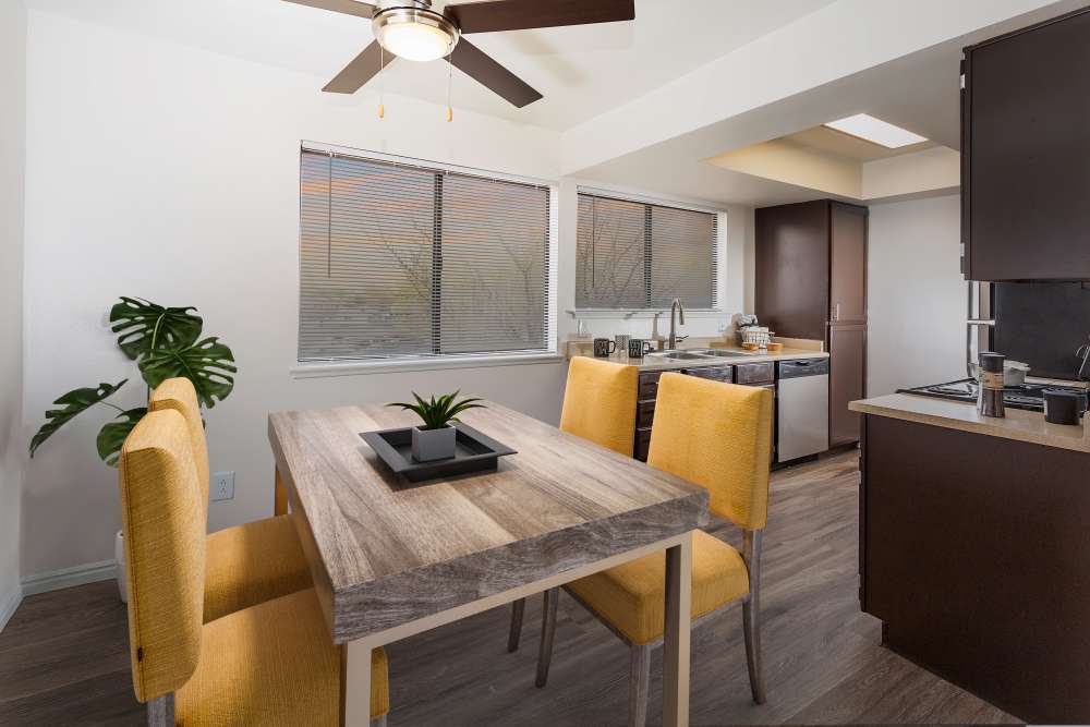 Spacious Dining Room and Kitchen with Renovated Brown Cabinetry at Shadowbrook Apartments in West Valley City, Utah