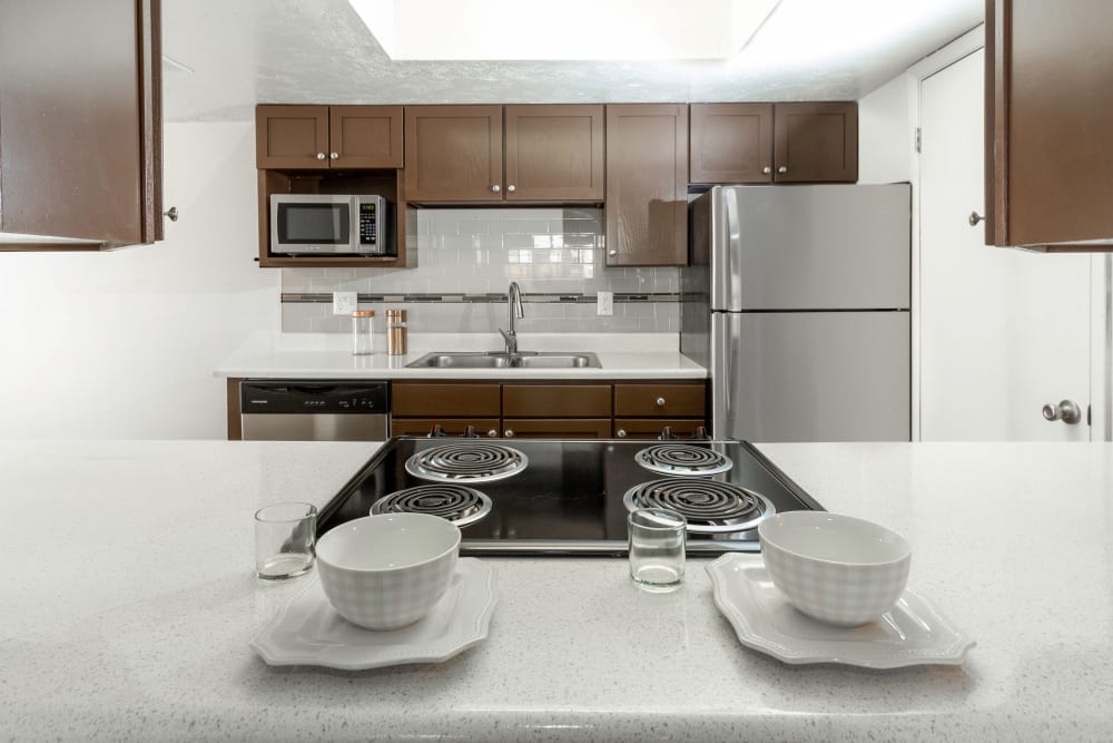 Renovated kitchen with warm brown cabinets at Windgate Apartments in Bountiful, Utah