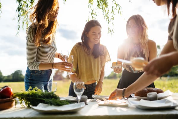 Residents enjoying a meal outside together at OLIVIAN at the Realm in Lewisville, Texas