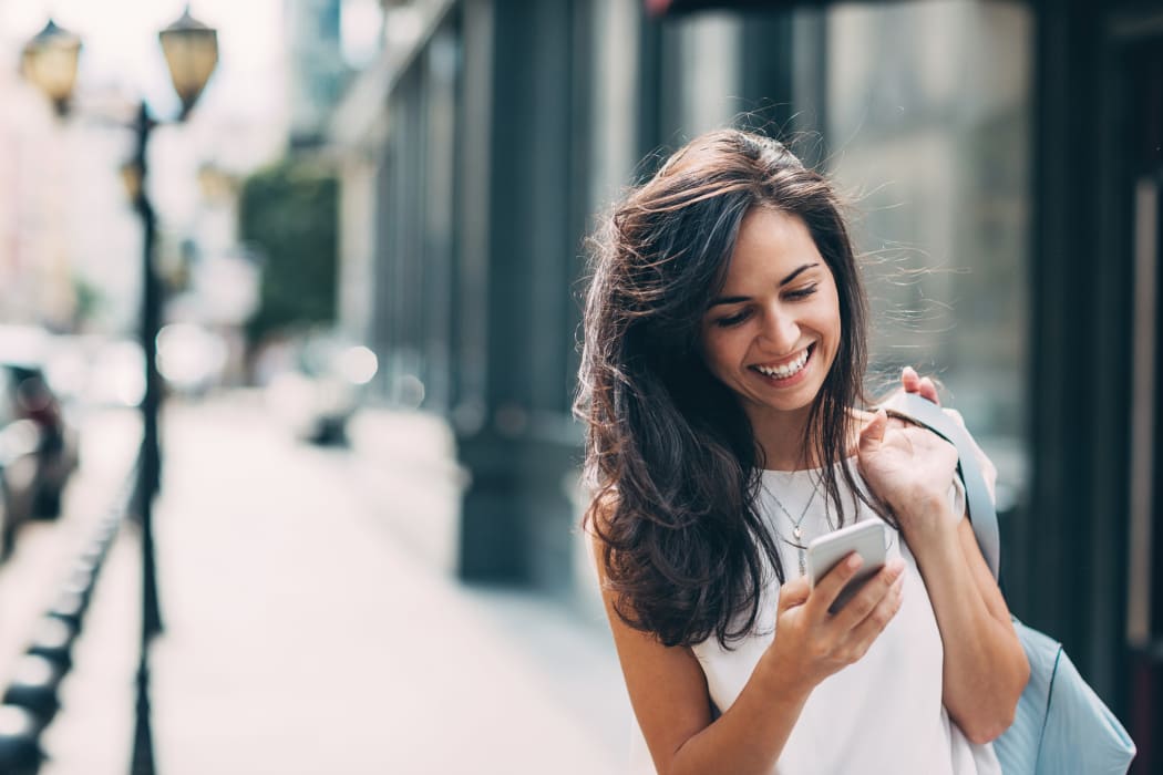 Young woman texting and walking near Allure in Alamo, California