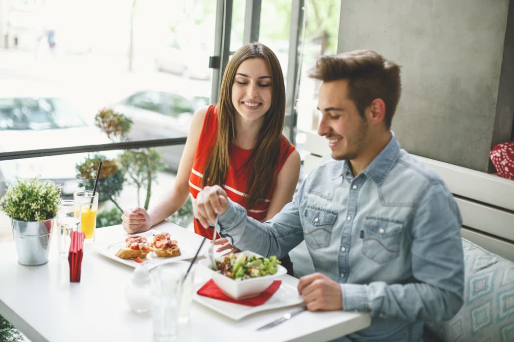 Smiling young couple having a lunch at a restaurant near Village Green of Bear Creek in Euless, Texas