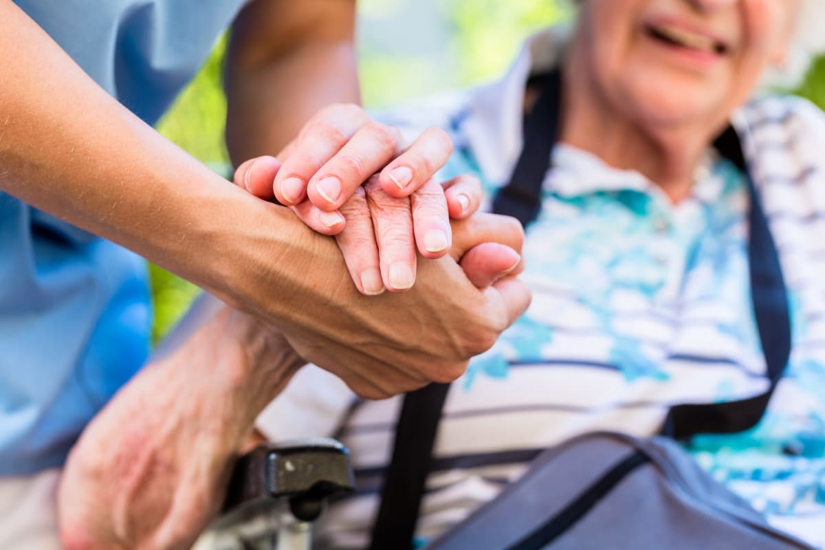 A resident holding hands with a caretaker at Keystone Place at Forevergreen in North Liberty, Iowa