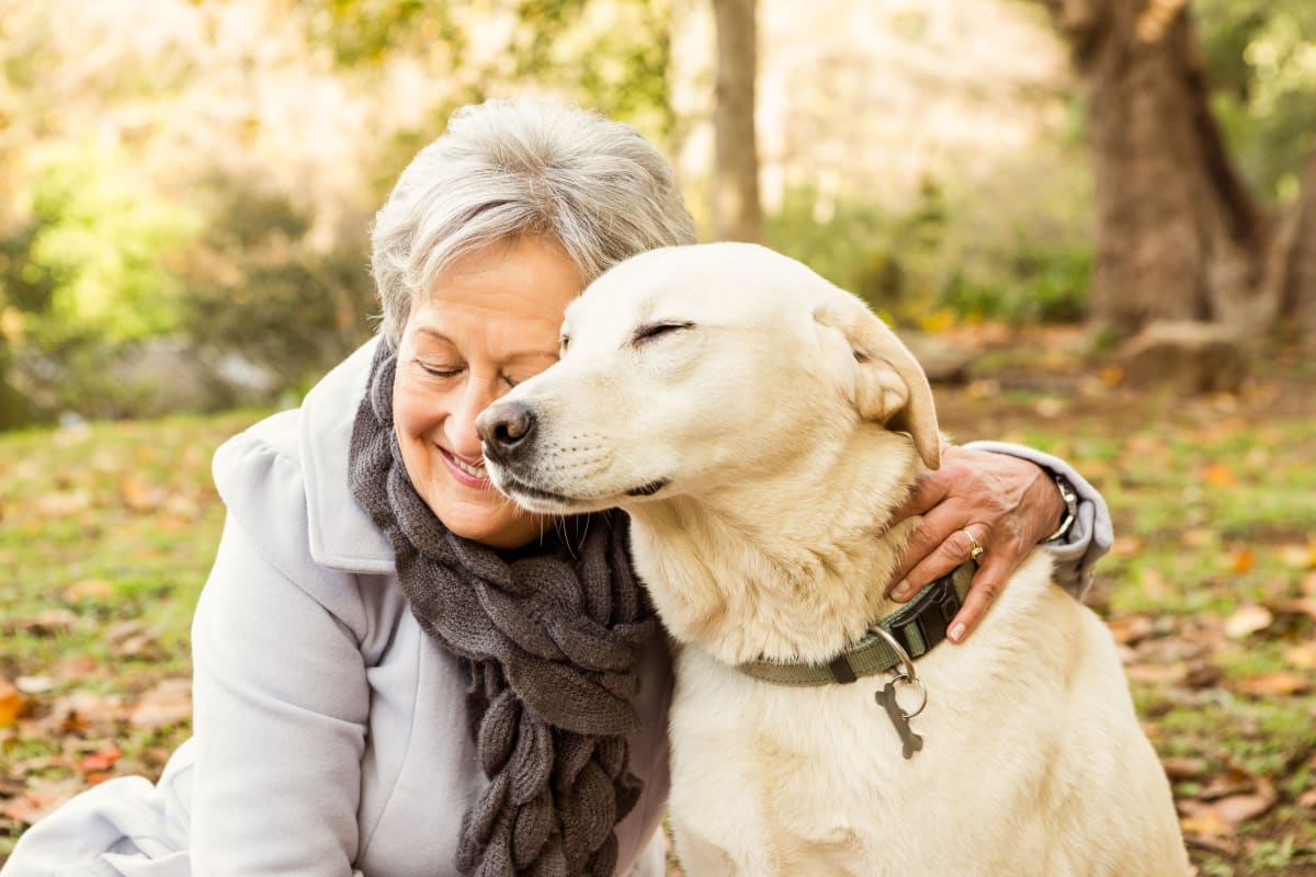 Resident sitting with her dog outside at Citrus Place in Riverside, California