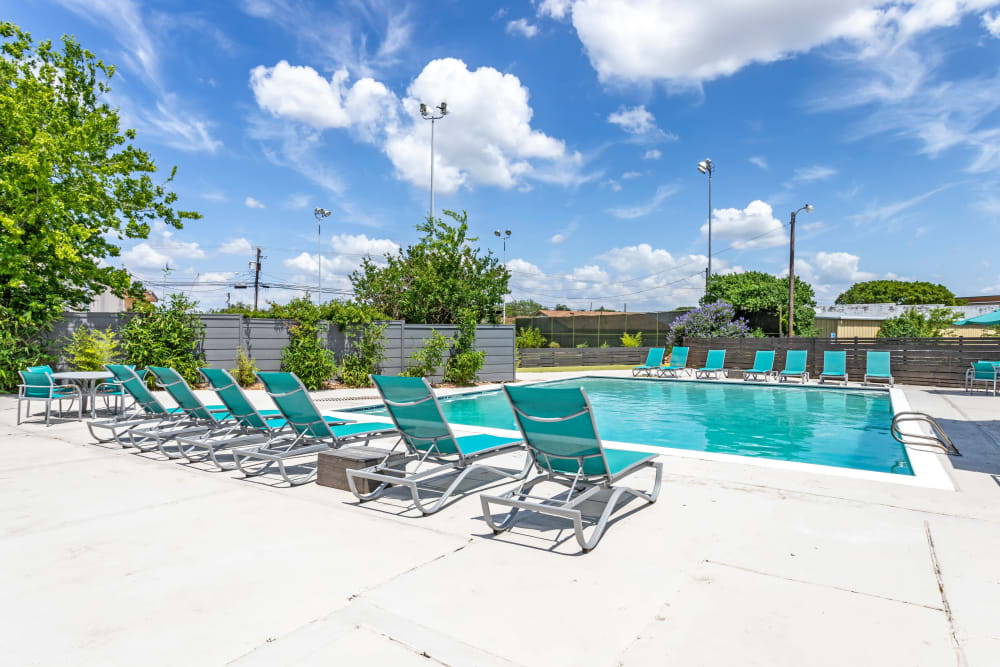 Sparkling pool and lounge chairs at EnVue Apartments in Bryan, Texas