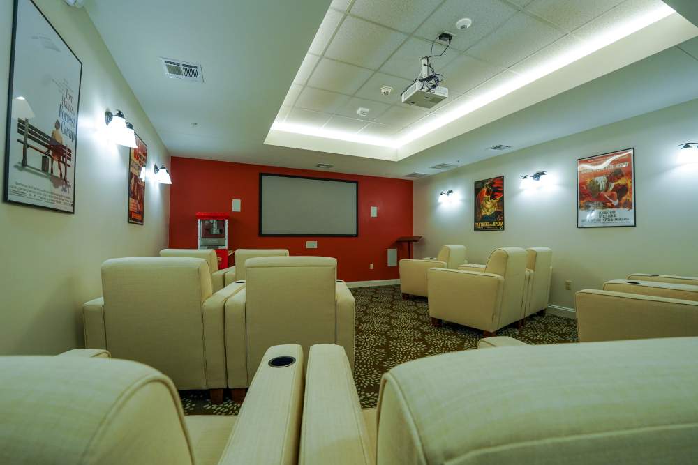 Theatre room with projector and recliners at Harmony on the Peninsula in Yorktown, Virginia