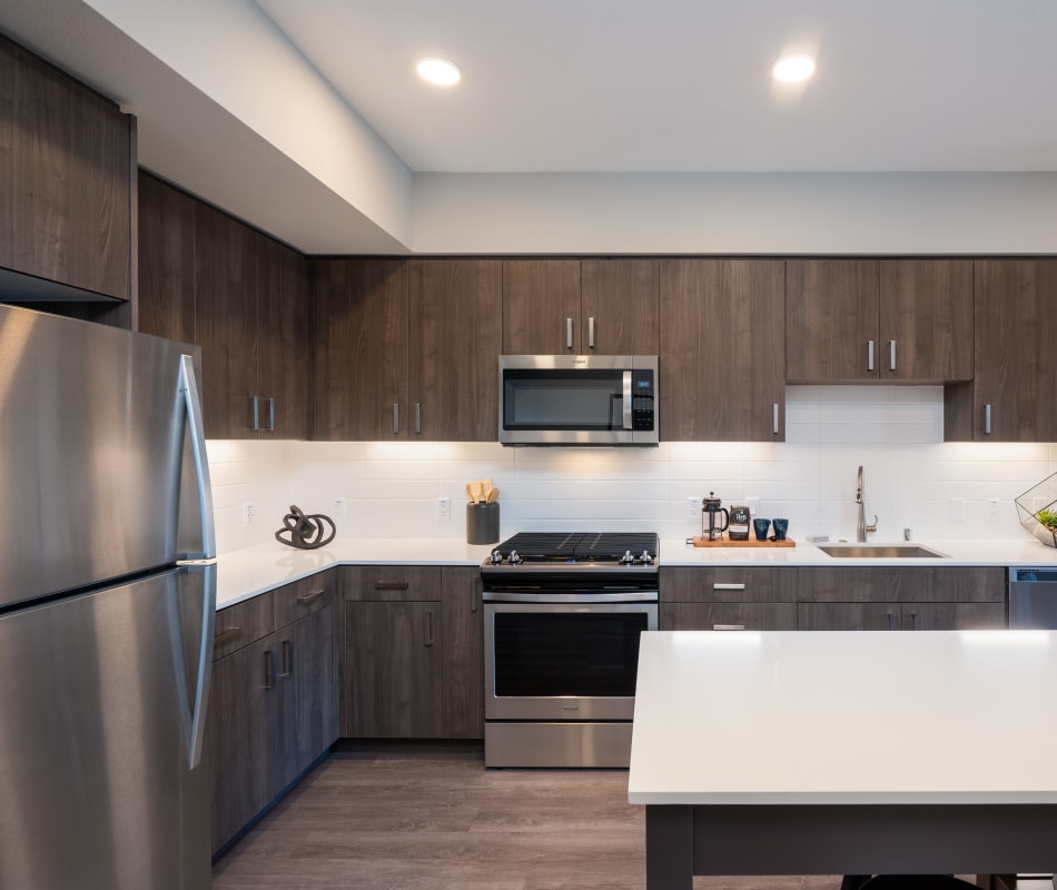 Modern kitchen with sleek, stainless-steel appliances in a model home at Anson in Burlingame, California