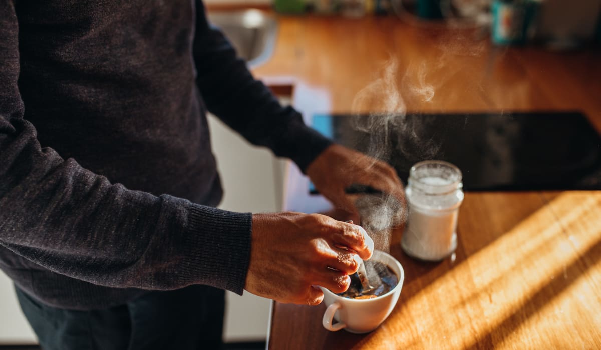 Resident making coffee in their modern kitchen at 933 The U in Rochester, New York 