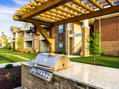 Gas grill with a spacious stone countertop underneath a pergola in the barbecue area at Valley Farms in Louisville, Kentucky