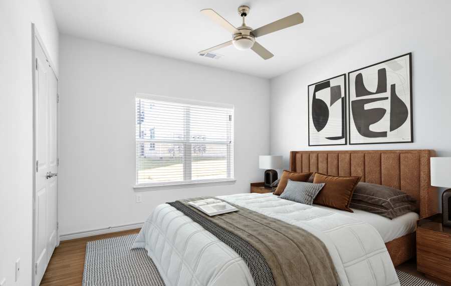 Elegant bedroom with wood-style flooring at Terrace at Southern Oaks in Dallas, Texas