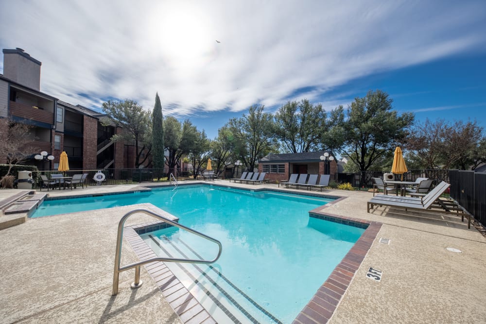 Resort style pool with lounge chairs at Trails of Towne Lake in Irving, Texas