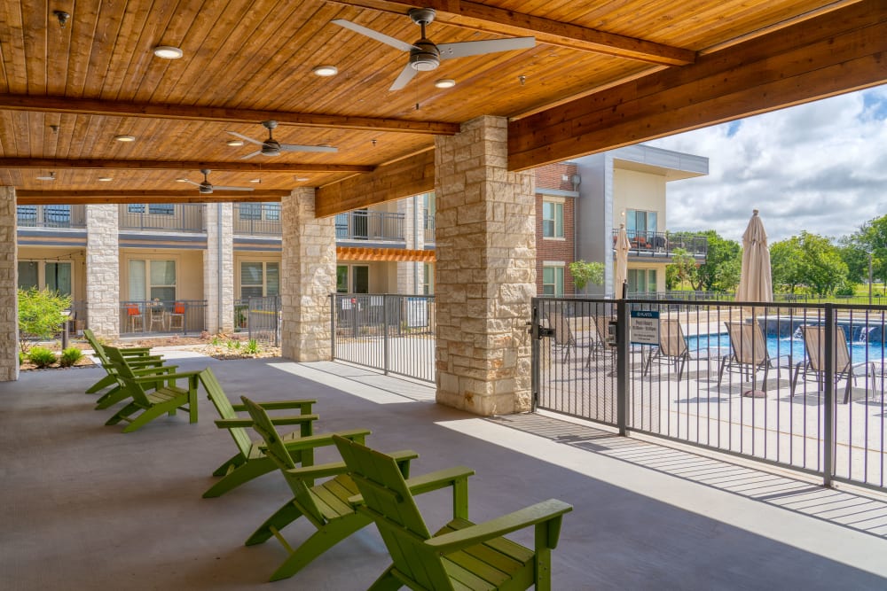 Lounge area in shaded region near pool at The Gates at Meadow Place in Willow Park, Texas