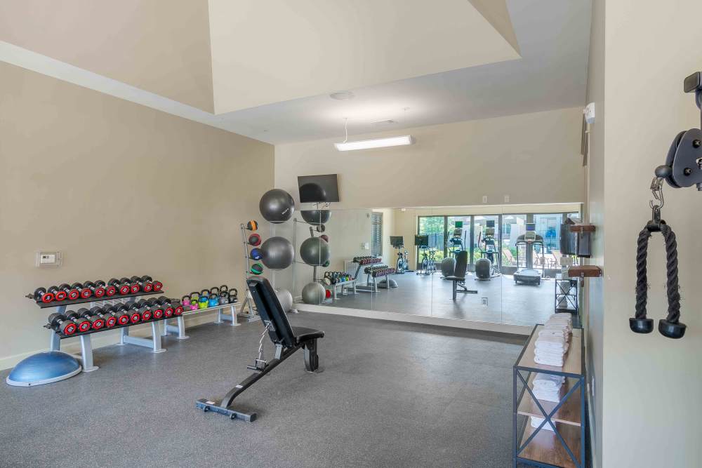 Gym with dumbbells at Boulders at Overland Park Apartments in Overland Park, KS