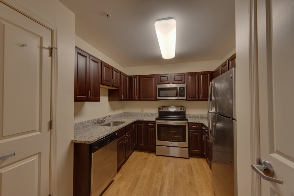 An apartment kitchen with stainless steel appliances at Harmony at Harbour View in Suffolk, Virginia